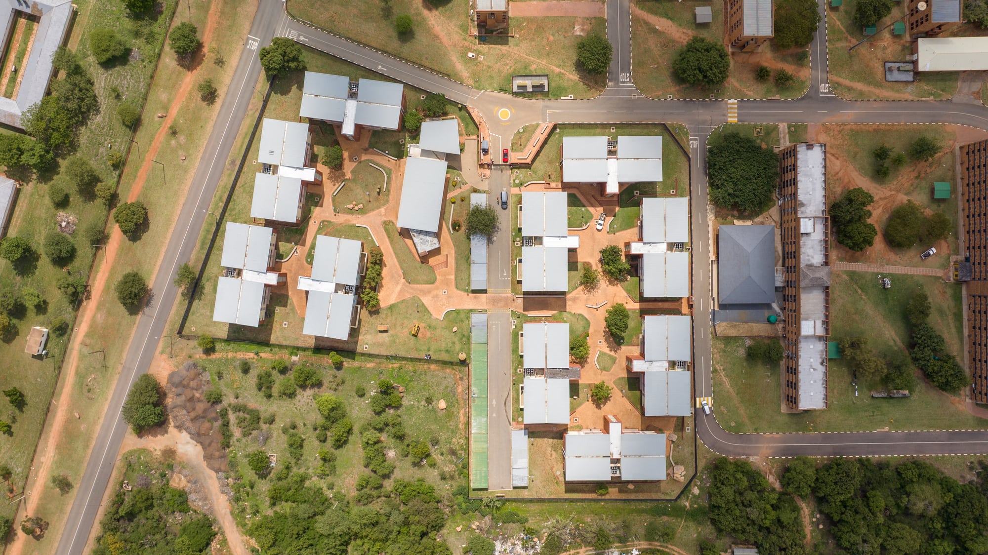 Residential blocks of the university student residence set across a landscaped, mountain-edge site